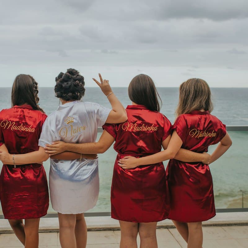 A bride and her bridesmaids in matching robes, seen from behind