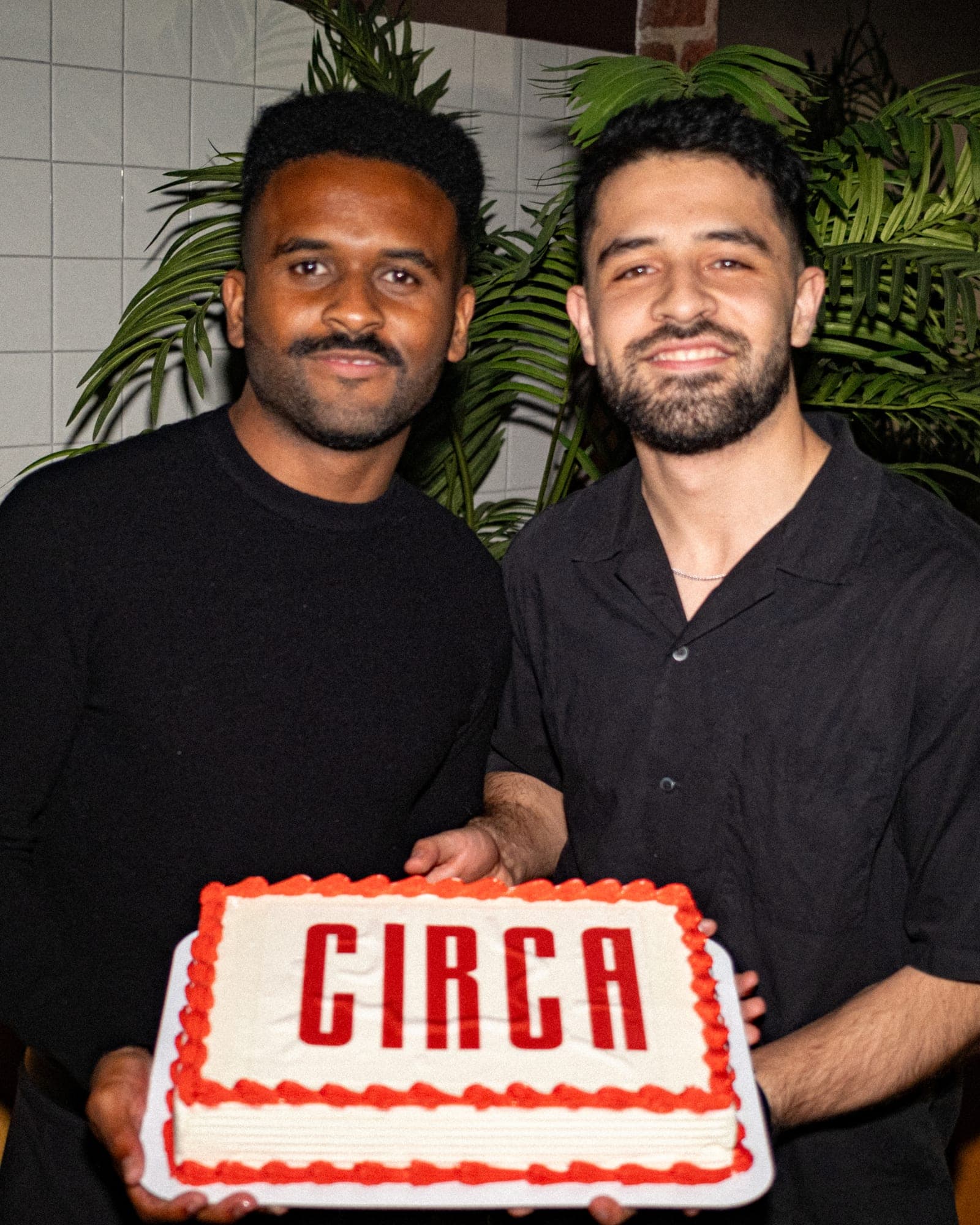 Two founders holding a Circa cake