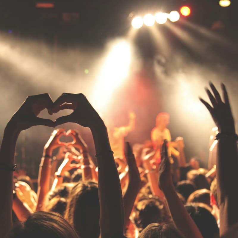 Hands making a heart shape at a concert