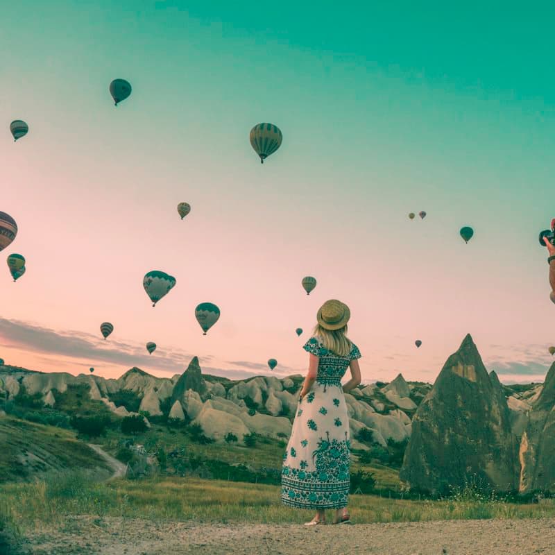 Two people photographing hot air balloons over Cappadocia