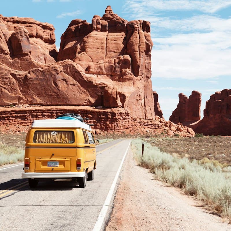 A yellow camper van on an open road