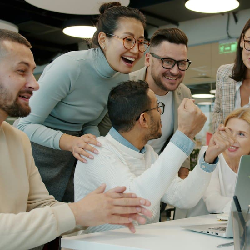 A team celebrating together at an office desk