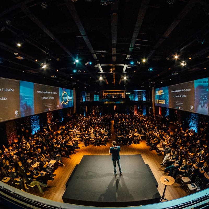 A speaker on stage in front of a large audience