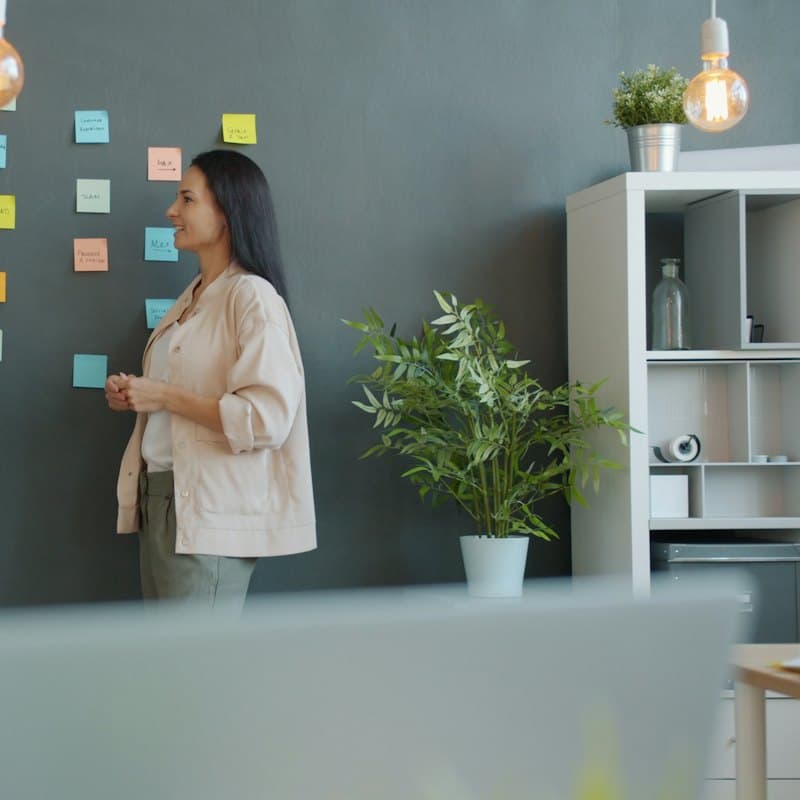A colleague putting sticky notes on a wall